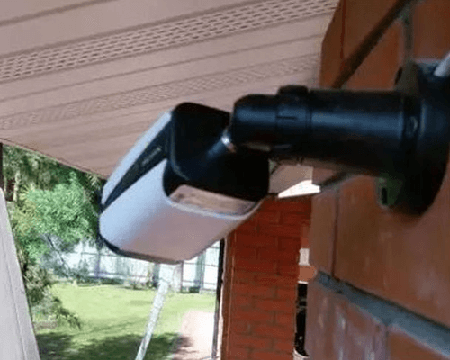 Видеокамера, установленная  на стене частного дома