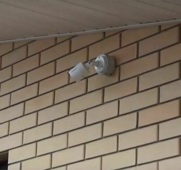 Видеокамера, установленная на стене частного дома