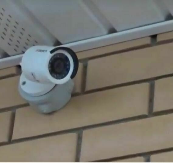 Видеокамера, установленная на стене под фронтоном